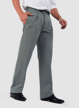 Man wearing sage green relaxed fit pleated trousers with a white striped shirt and black shoes.